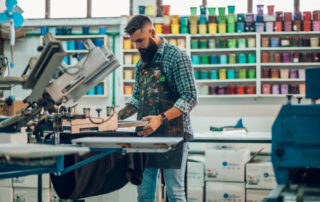 Male Worker Using Printing Machine In A Workshop