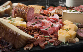 Cured Meat And Cheese Platter With Nuts, Crackers, Crusty Bread And White Wine