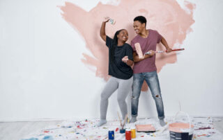 Shot Of A Young Couple Painting A Wall Pink