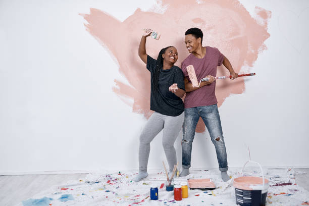 Shot Of A Young Couple Painting A Wall Pink