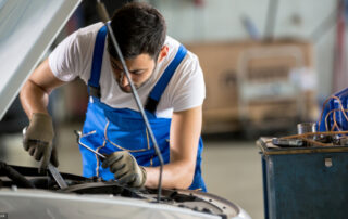 Auto Mechanic Working Under The Hood